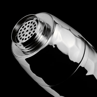 Chrome hexclad cocktail shaker open top on a black background